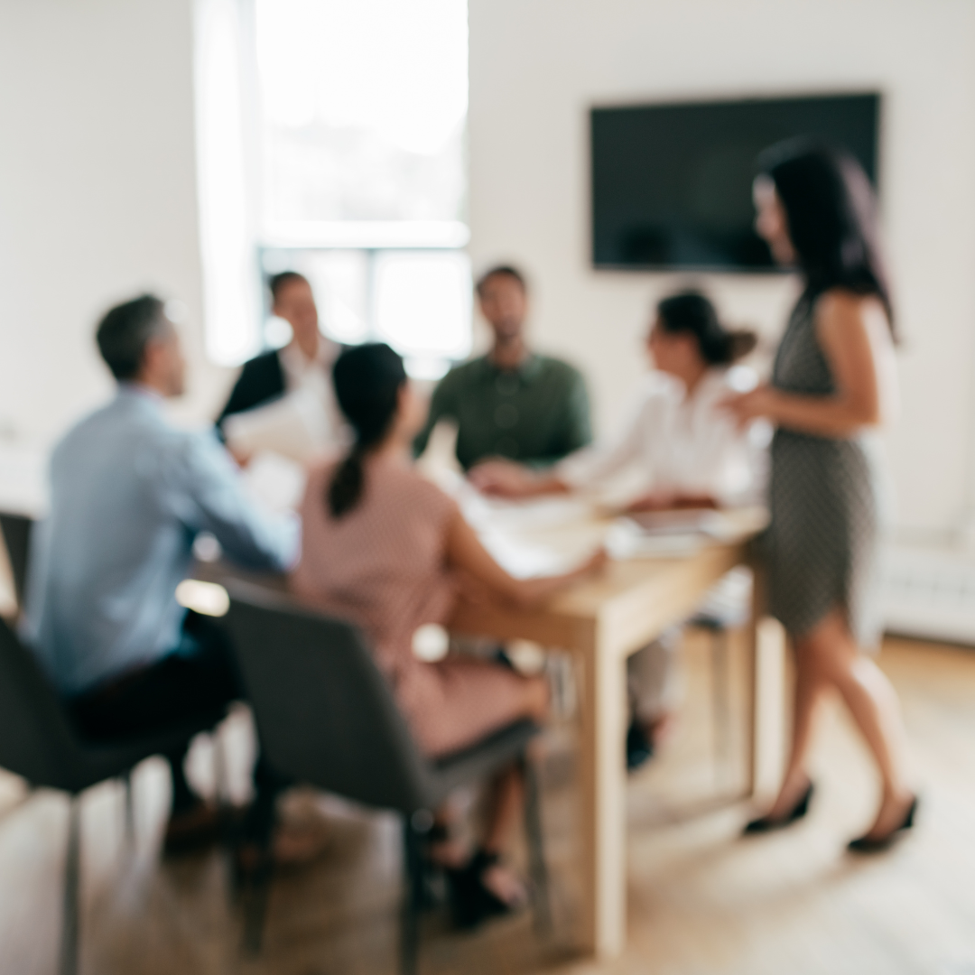 A blury photo of people in a meeting