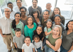 A group of people with different ages smiling. Navigating Business Transitions with Clarity and Confidence.
